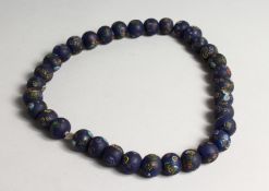 POSSIBLY ROMAN, A SEVENTEEN RED MILLEFIORI GLASS NECKLACE.