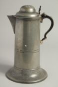 AN 18TH CENTURY PEWTER FLAGON AND COVER on a large circular base. 11ins high.