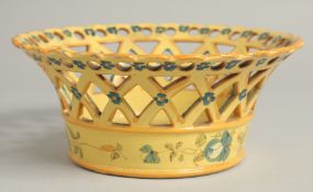 A CONTINENTAL YELLOW GROUP PIERCED CIRCULAR BASKET painted with flowers. 8ins diameter.