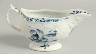 AN 18TH CENTURY EARLY LOWESTOFT FINE SAUCE BOAT painted with a landscapes on a moulded body,