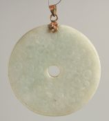 A GOLD TOP CIRCULAR JADE PENDANT. 2.25ins diameter.