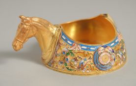 A RUSSIAN SILVER GILT AND ENAMEL CIRCULAR KOVSCH with horse’s head handle 3.5ins diameter. Mark