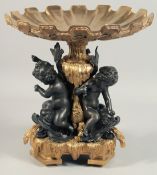 A GOOD ONYX AND BRONZE CHINESE STYLE TAZZA held by three cherubs. 13ins high.
