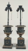 A PAIR OF CLASSICAL TWO HANDLED URN SHAPED VASES on pedestal, as lamps. 2ft 3ins high.