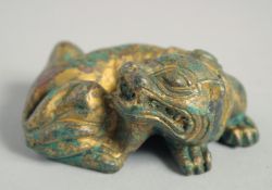 A CHINESE GILDED METAL LION LYING DOWN. 7cm long.