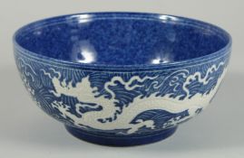 A CHINESE BLUE BOWL the sides with white dragons. 10ins diameter.
