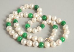A STRING OF APPLE JADE AND PEARL NECKLACE.