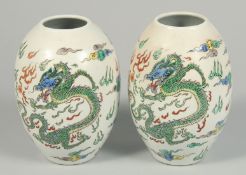 A PAIR OF CHINESE VASES decorated with dragons. 8.5ins high.