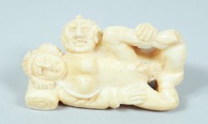 AN EROTIC CARVED BONE NETSUKE.