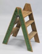 A NOVELTY PAIR OF GREEN FOLDING WOODEN STEPS.
