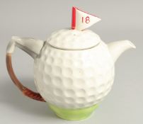 A TONY WOOD GOLF BALL TEA POT AND COVER. 8ins high