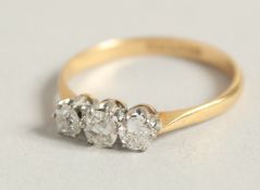 AN 18 CARAT THREE STONE DIAMOND RING. Size O.