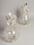 A PAIR OF GLASS AND PLATE CLARET JUGS.