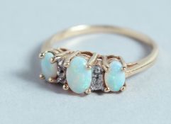 A THREE STONE OPAL AND DIAMOND RING.