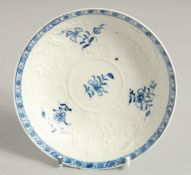 AN EARLY 18TH CENTURY, RARE LOWESTOFT SAUCER, moulded with flowers and cartouches, each painted with
