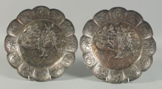 A PAIR OF JAPANESE SILVERED SHAPED DISHES repousse with warriors.