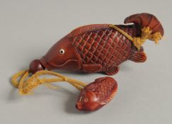 A CARVED WOOD CARP INRO with rope.