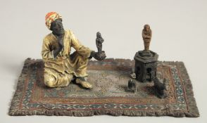 A VIENNA PAINTED BRONZE ARAB SELLING AMULETS sitting on a Persian rug. 7ins long.