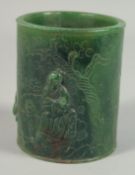 A JADE POT carved with figures in relief. 4.5ins high.
