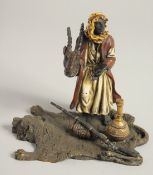 A VIENNA PAINTED BRONZE ARAB holding a trophy head and standing on a lion skin rug. 5ins high.