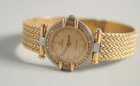 A LADIES 18CT GOLD OMEGA CONSTELLATION WRISTWATCH AND BRACELET surrounded by diamonds.