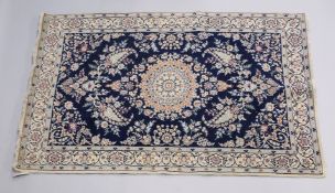 A PERSIAN RUG blue ground with central loral medallion within a cream ground floral border. 6ft 9ins