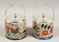 A PAIR OF PORCELAIN BISCUIT BARRELS with plated top and handle.
