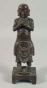 A CHINESE BRONZE STANDING PRAYING FIGURE on a square base. 12ins high.