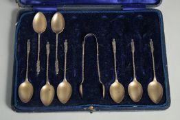 A SET OF EIGHT SILVER GILT APOSTLE TEASPOONS AND SUGAR TONGS in a fitted case. Birmingham 1912.