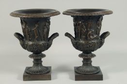 A GOOD PAIR OF CLASSICAL BRONZE TWO HANDLED URN SHAPED VASES with figures, on square stands.