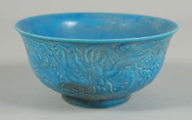 A SMALL CHINESE BLUE PORCELAIN CIRCULAR BOWL with dragons in relief. 6ins diameter.