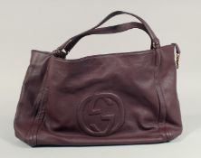 A LARGE GUCCI MAROON LEATHER SOFT BAG, 'G' on the side. 18ins x 12 ins with two leather handles.