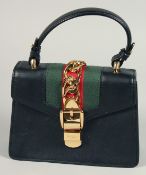 A GOOD GUCCI SMALL CLUTCH BAG 7.5ins x 5.5ins with gilt Gucci lock and leather handles.