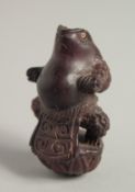A CARVED WOOD FROG NETSUKE.