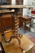 A mahogany circular occasional table on barley twist column support with three carved legs.