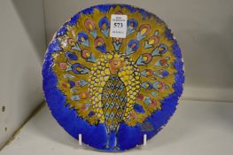 An Iznik style circular pottery tile painted with a peacock.