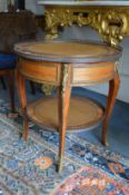 A French kingwood and ormolu mounted circular two-tier occasional table with lifting top.