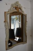 A decoratively carved and painted mirror with basket of fruit finial.