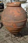 A large Continental terracotta jar on wrought iron stand.