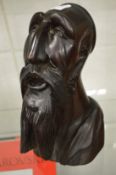 A carved wood bust of a bearded man.
