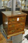 A Regency rosewood and brass inlaid miniature three drawer chest.