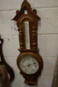 A Victorian barometer/thermometer with carved oak frame.