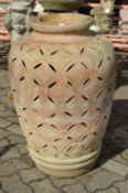 A large terracotta urn with pierced decoration.