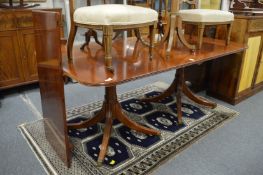 A reproduction mahogany twin pedestal dining table with one leaf.