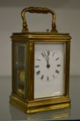 A brass carriage clock with repeat movement (dial cracked).
