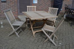 A hardwood folding garden table with four chairs.