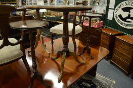 A mahogany tilt top tripod table and a pair of candle stands.