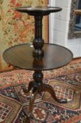 A mahogany two tier circular dumb waiter on tripod base.
