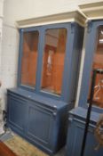 A blue painted cupboard bookcase.