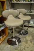 A pair of modern upholstered and chrome bar stools.